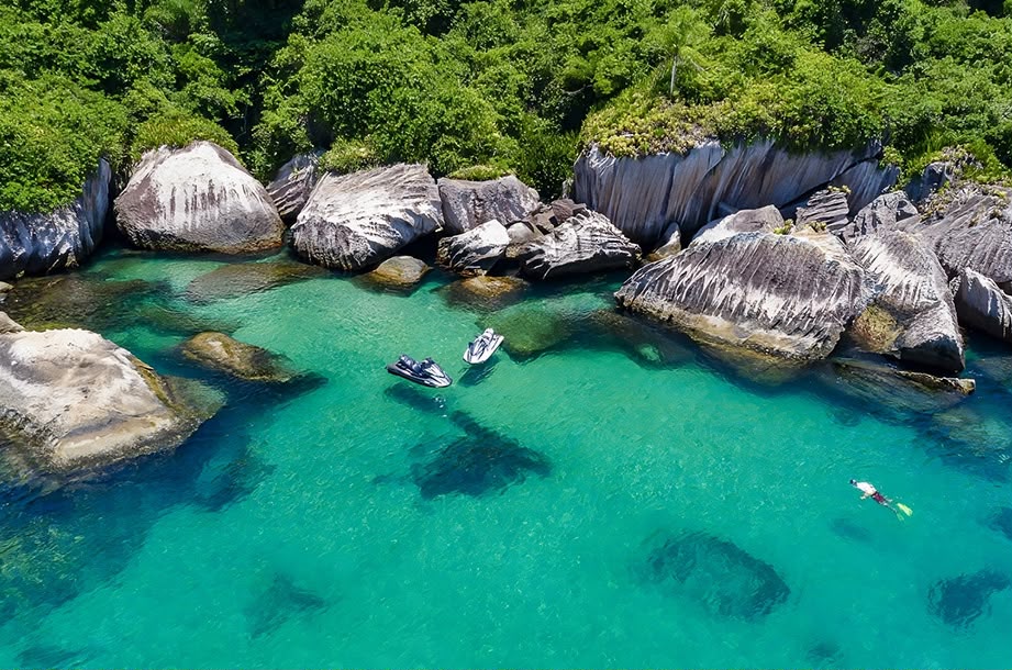 Banhistas mergulhando em enseada de águas cristalinas em Barra do Una